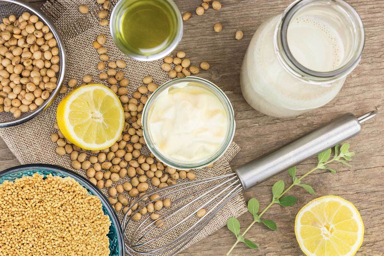 Soy mayonnaise, lemon, soybeans,tofu and metallic whip, on woode